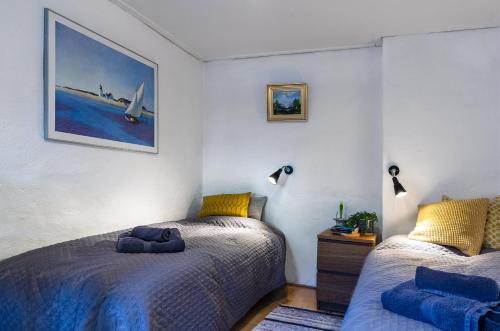 a bedroom with two beds and a picture on the wall at Innergårdens Bed and Breakfast in Karlshamn