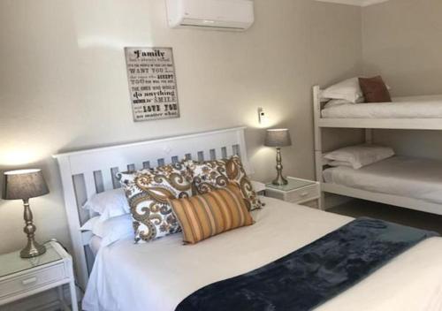 a bedroom with a white bed with pillows on it at Wagon Wheel Country Lodge in Beaufort West