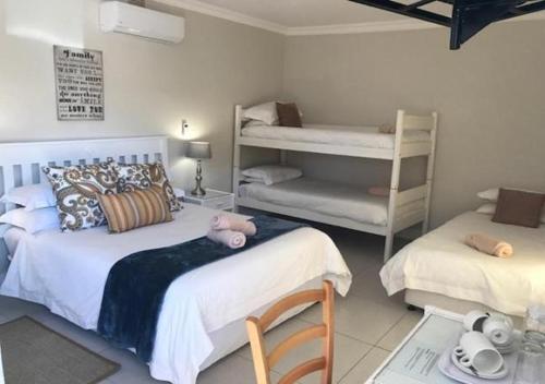 a bedroom with two beds and a bunk bed at Wagon Wheel Country Lodge in Beaufort West