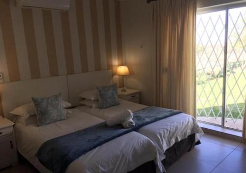 a bedroom with a large bed with a large window at Wagon Wheel Country Lodge in Beaufort West