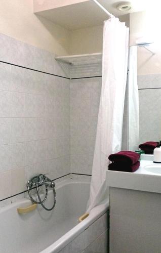 une salle de bain blanche avec une baignoire et un lavabo dans l'établissement Cosy - Negresco - AC - 5 min walk to Beach, à Nice