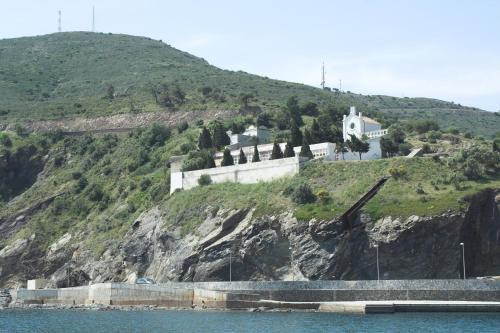 a house on the side of a hill next to the water at Hostal Juventus in Portbou
