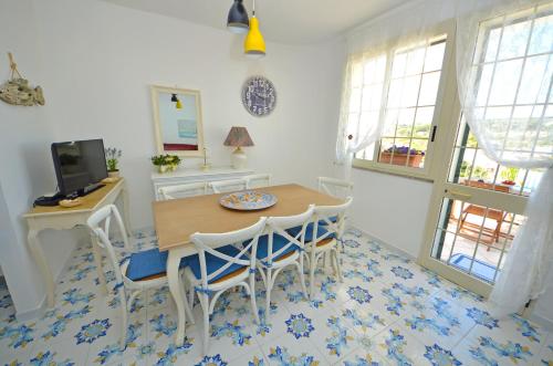 a dining room with a table and chairs and a tv at Casa Baia Tramonto in Patù