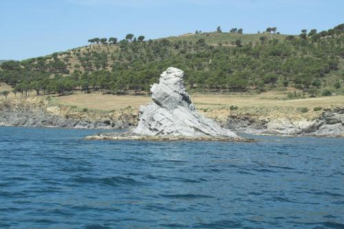 a rock formation in the middle of the water at Hostal Juventus in Portbou