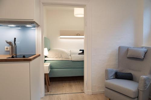 ein Wohnzimmer mit einem Sofa und einem Stuhl in der Unterkunft Smaaland in Flensburg
