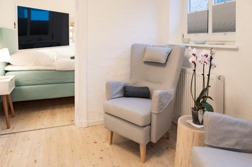 a living room with a chair and a bedroom at Smaaland in Flensburg