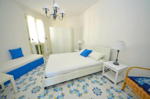 a white bedroom with a bed and a table at Casa Baia Tramonto in Patù