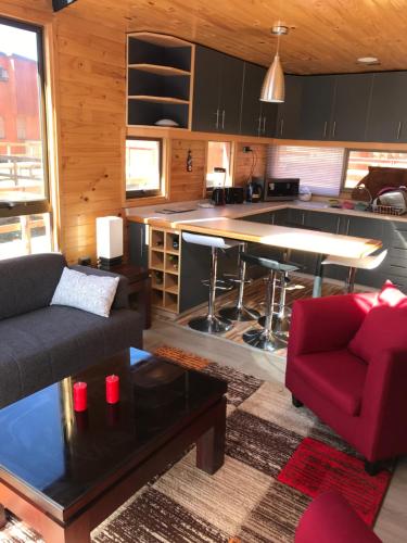 sala de estar con sofá rojo y cocina en Condominio Privado a Pasos del Mar, en Pichilemu