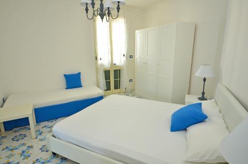 a white bedroom with a bed and a window at Casa Baia Tramonto in Patù