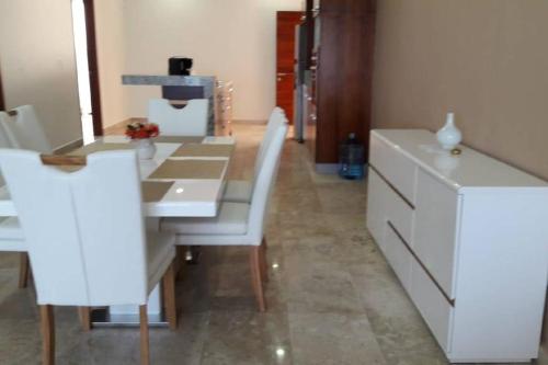 a dining room with a white table and white chairs at Deluxe New Beachfront Penthouse in Akumal in Akumal