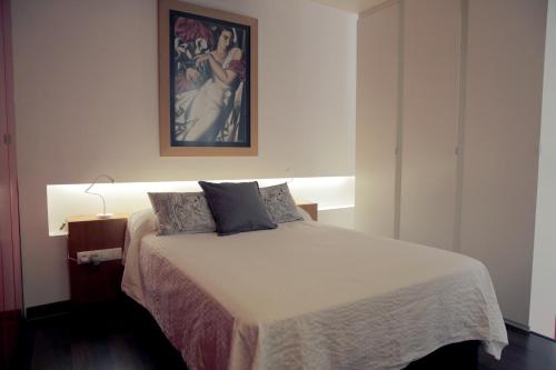 a bedroom with a bed and a painting on the wall at Loft Bordador in Seville