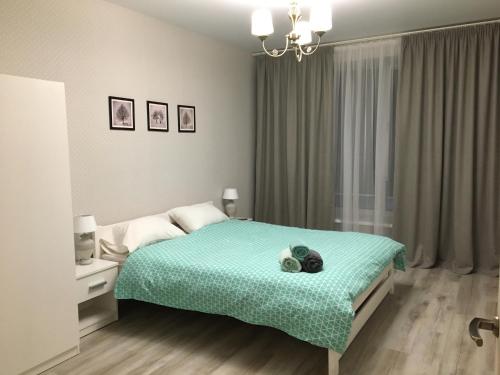 a bedroom with a bed with a blue comforter at Софиевский квартал in Petropavlovskaya Borshchagovka