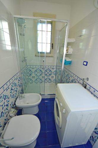 a bathroom with a toilet and a sink and a shower at Casa Baia Tramonto in Patù