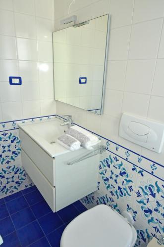 a bathroom with a toilet and a sink and a mirror at Casa Baia Tramonto in Patù