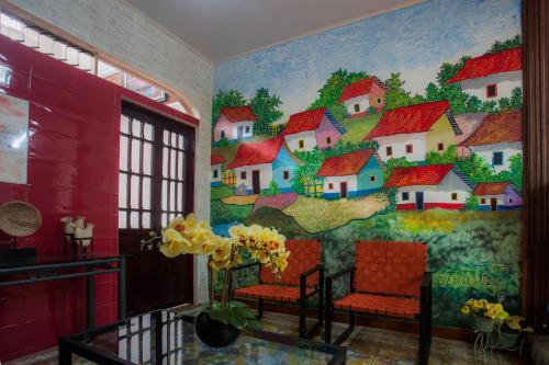 a room with a mural of houses on the wall at Boutique Hotel Casa Orquídeas in San José