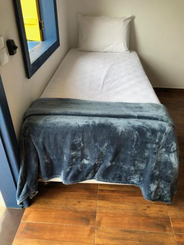a bed with a black blanket on it in a room at João e Maria Restaurante e Chalés in Tiradentes