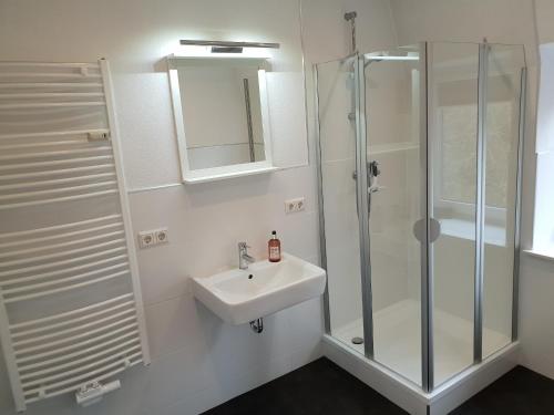 a white bathroom with a sink and a shower at Apartment 28 in Coburg