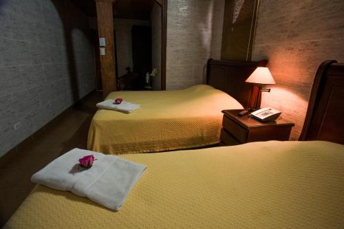 a hotel room with two beds with towels on them at Boutique Hotel Casa Orquídeas in San José