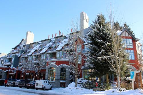 a large red building with snow on the ground at Alpenglow Lodge by MVA in Whistler