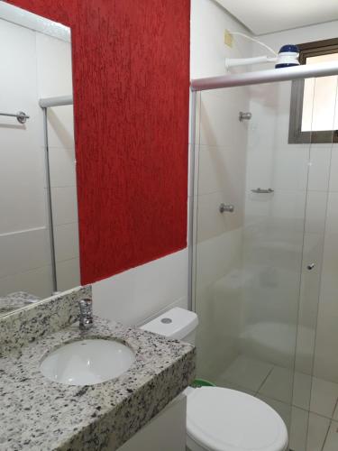 a bathroom with a sink and a toilet and a mirror at Aldeia do Lago C104- Churrasqueira, bebidas liberadas nas piscinas, internet no ap, rampa no lago, pesqueiro, carregador carro elétrico in Caldas Novas