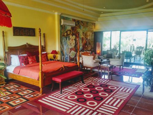 a bedroom with a bed with a red comforter and a rug at Bali Paradise Hotel Boutique Resort in Lovina