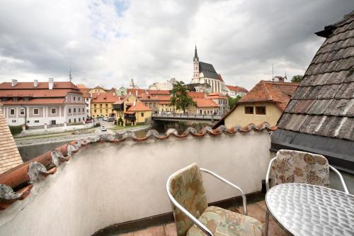 a view of a city from a balcony with a table and chairs at Pension U Hada in Český Krumlov
