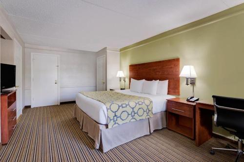 Habitación de hotel con cama grande y escritorio. en Baymont by Wyndham Jacksonville Orange Park, en Jacksonville