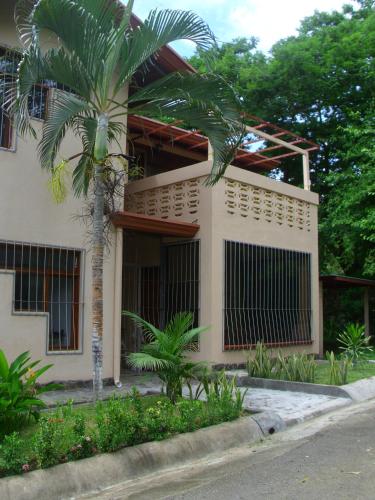a house with a palm tree in front of it at Condominio Villa Hermosa in Playa Hermosa