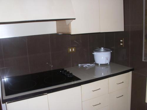 a kitchen with white cabinets and a black counter top at Condominio Villa Hermosa in Playa Hermosa