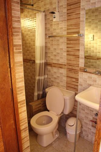 a bathroom with a toilet and a sink at Kennedy Guest House in Cusco