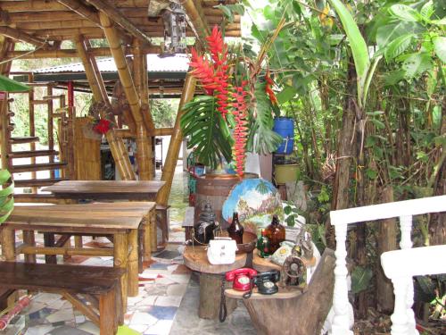 a patio with wooden tables and a vase with flowers at Hospedaje Rural Tupinamba in Ibagué