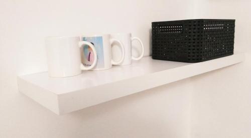 a shelf with three mugs and a basket on it at Alabama in Kyiv