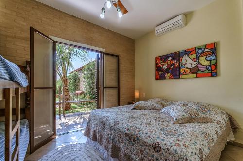 ein Schlafzimmer mit einem Bett und einem großen Fenster in der Unterkunft Estilo Cabana in Santa Rita do Passa Quatro