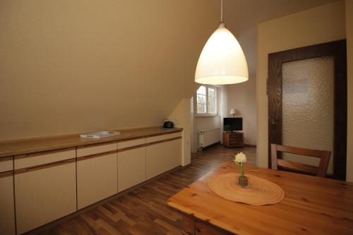 eine Küche mit einem Tisch mit einer Vase mit Blumen darauf in der Unterkunft Strandroggen in Wangerland