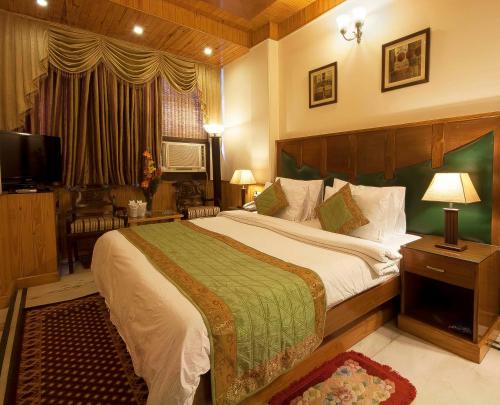 sypialnia z dużym łóżkiem i telewizorem w obiekcie Wood Castle w Nowym Delhi