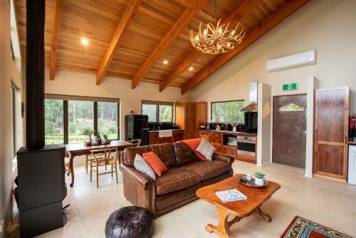 a living room filled with furniture and a large window at Adventure Bay Retreat Bruny Island in Adventure Bay
