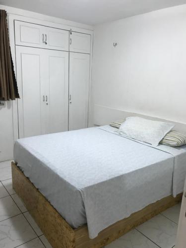 a bed in a white room with white cabinets at Apartamento na melhor localização de fortaleza!! in Fortaleza