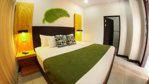 a bedroom with a large bed with a green blanket at Apartamentos Equipados RyA del Volcán in Fortuna