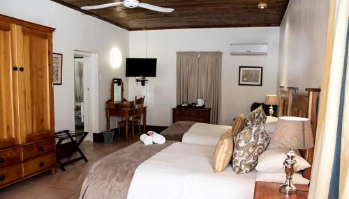 a bedroom with a large bed and a desk at Matoppo Inn in Beaufort West