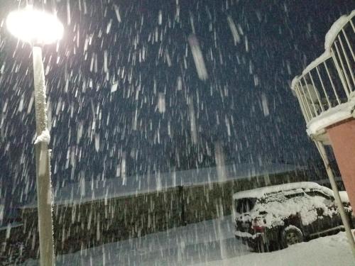 a bus parked next to a street light in the snow at Little Star in Stepantsminda