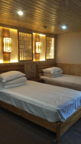 Postel nebo postele na pokoji v ubytování Nanjing Tulou Qingdelou Inn