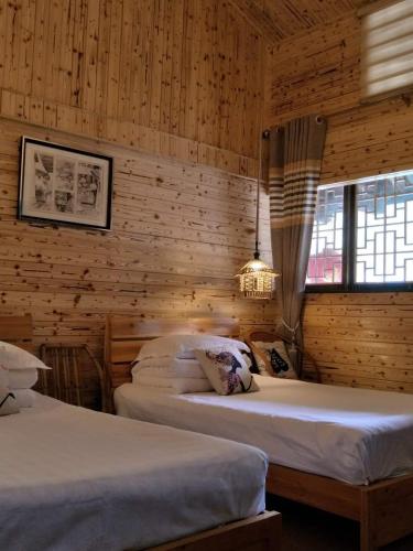 Postel nebo postele na pokoji v ubytování Nanjing Tulou Qingdelou Inn