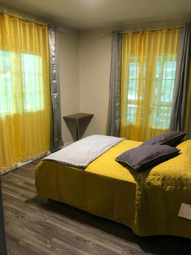 Schlafzimmer mit gelbem Bett und gelben Vorhängen in der Unterkunft Le Guétali in Salazie