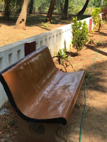 a brown bench sitting next to a white fence at All Seasons Guest House in Vasco Da Gama
