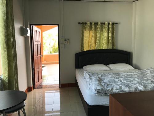 a bedroom with a bed and a door to a patio at Rubtawan Sichang Resort in Ko Si Chang