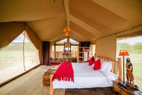 um quarto com uma cama numa tenda em Asanja Moru em Parque Nacional Serengeti