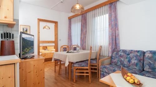 a living room with a table and a couch at Wellness Landhaus Parth in Ossiach