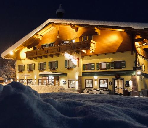 a large building in the snow at night at Landgasthof Reitsamerhof in Werfen