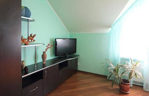 a living room with a television on a dresser at Maxima in Kamianets-Podilskyi