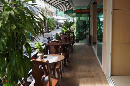 a restaurant with tables and chairs and potted plants at Patong Mansion - SHA Certified in Patong Beach